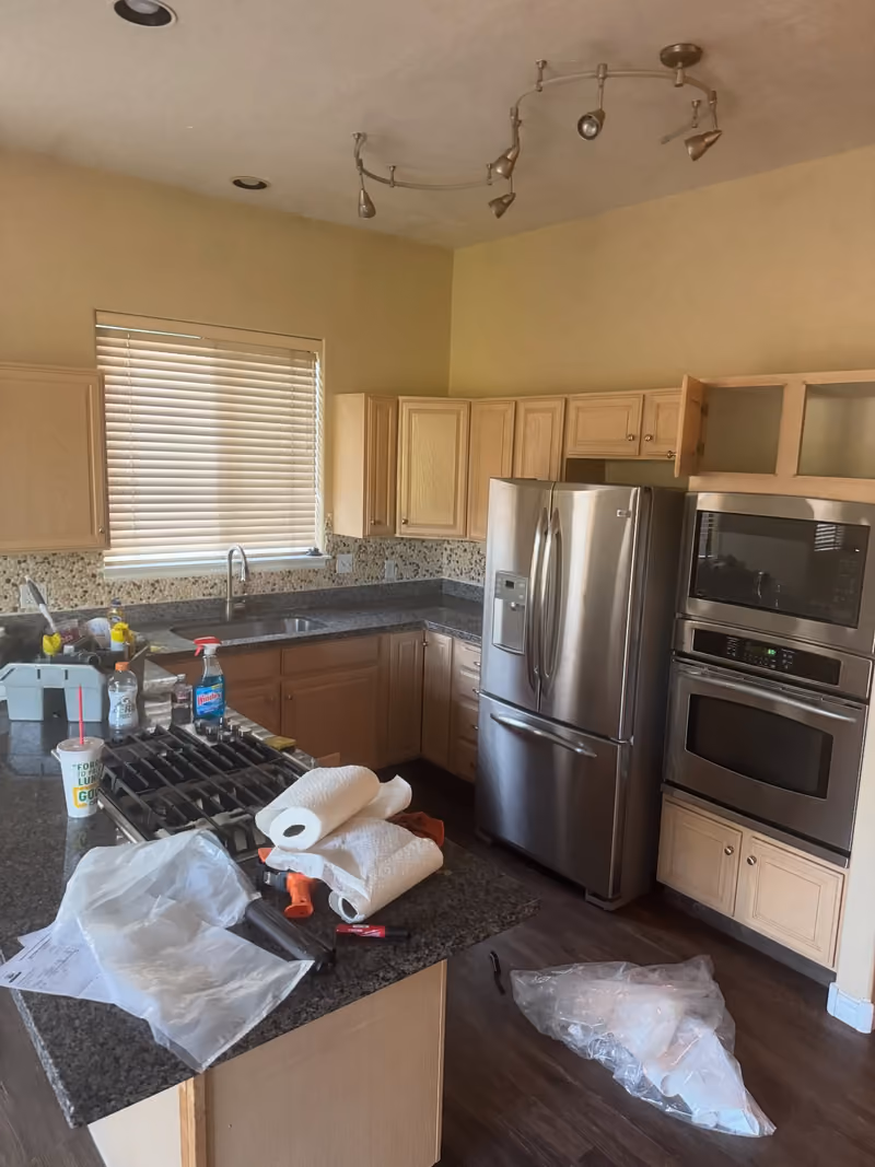 Before: kitchen counters covered in paper towels, bottles, and plastic wrap