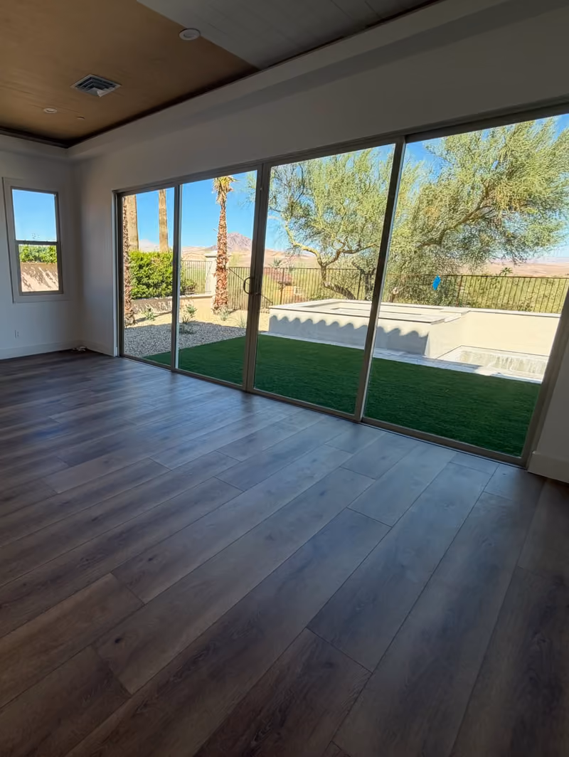 After: the same room with clean floors and clear glass looking out on the yard