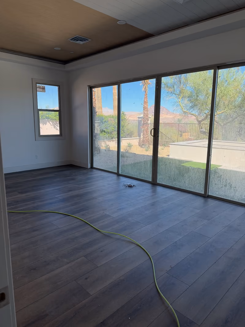 Before: new room with a dusty floor, a cord across it, and hazy glass doors